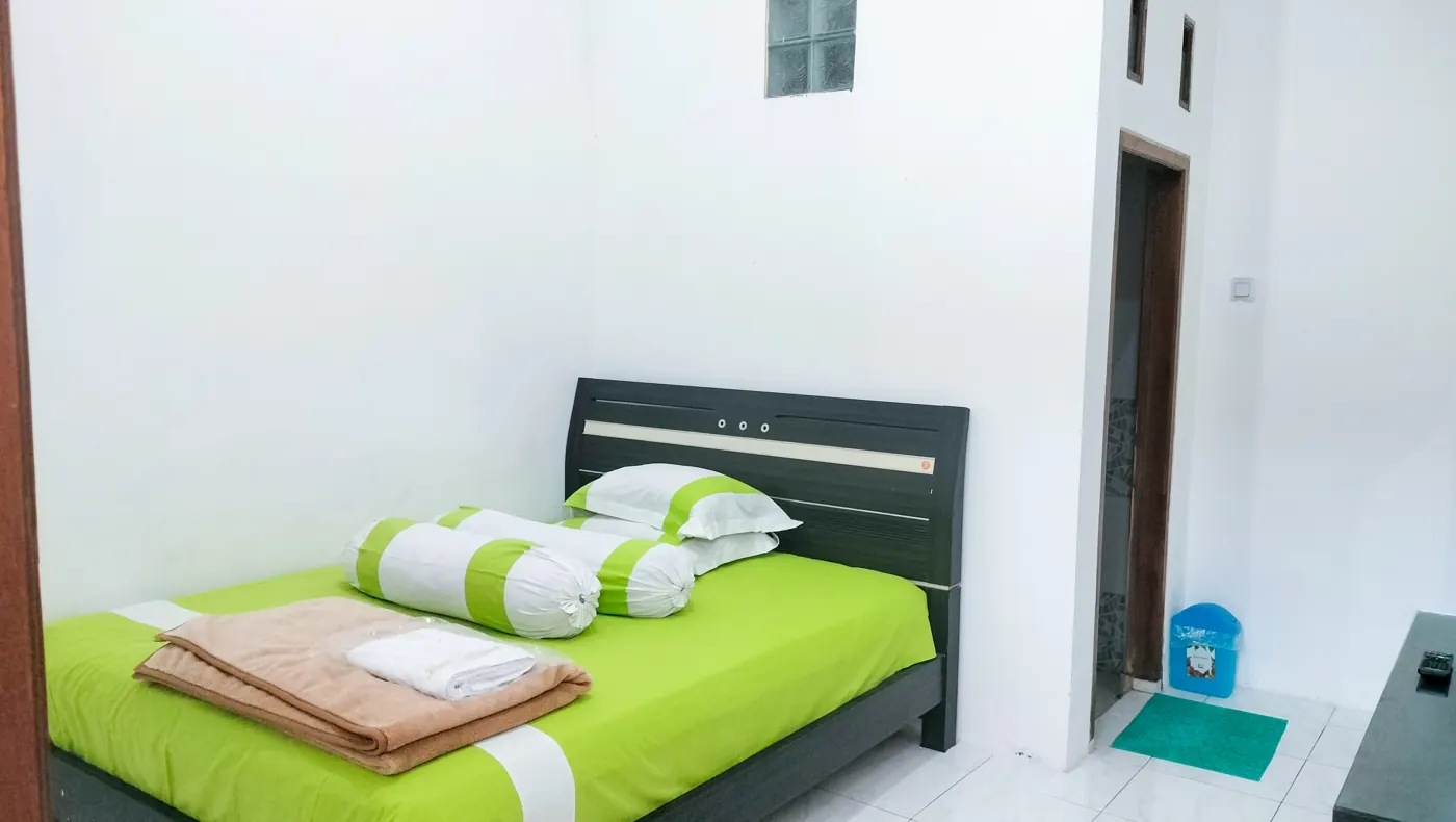 Executive Room dengan queen bed sprei hijau
